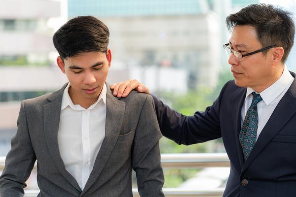 Man comforting his colleague