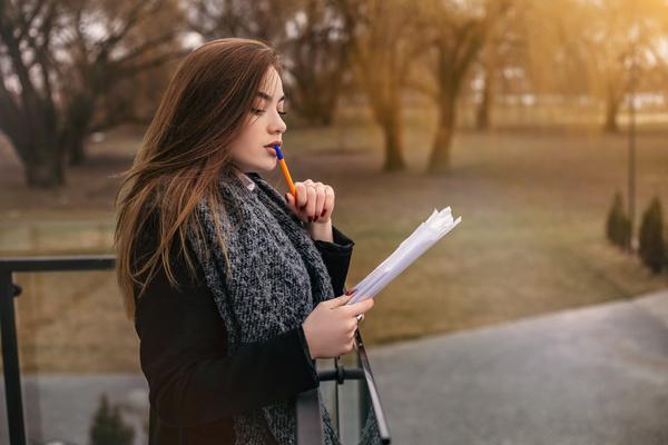 woman editing papers outside