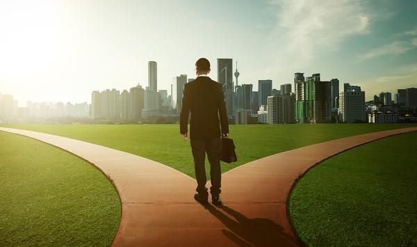 Business man at a crossroads in front of a city