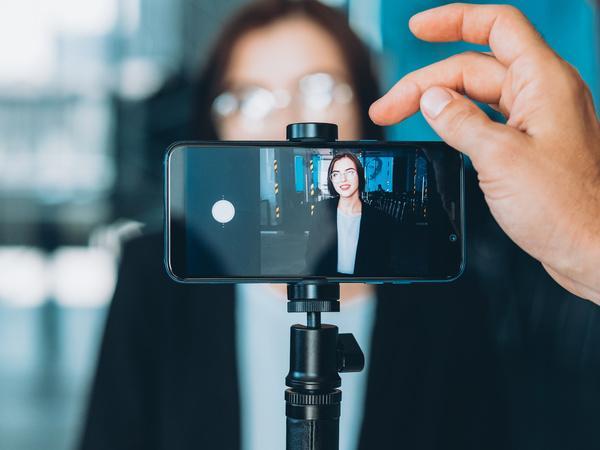 Woman recording herself on her phone on a tripod