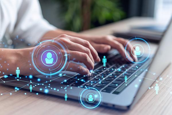 Man working on his laptop with blue icons over the image