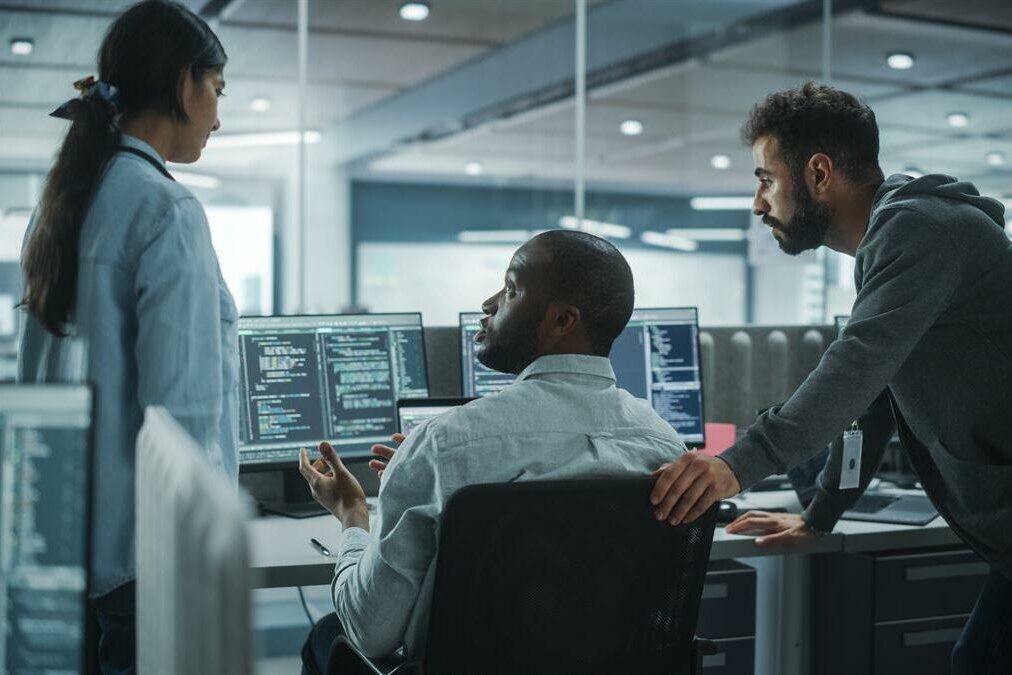 Diverse Group of Energetic Professionals Team Meeting in Modern Office: Brainstorming IT Programmers Use Computer, Talk Strategy, Discuss Analysis. Innovative Software Engineers Develop App Program