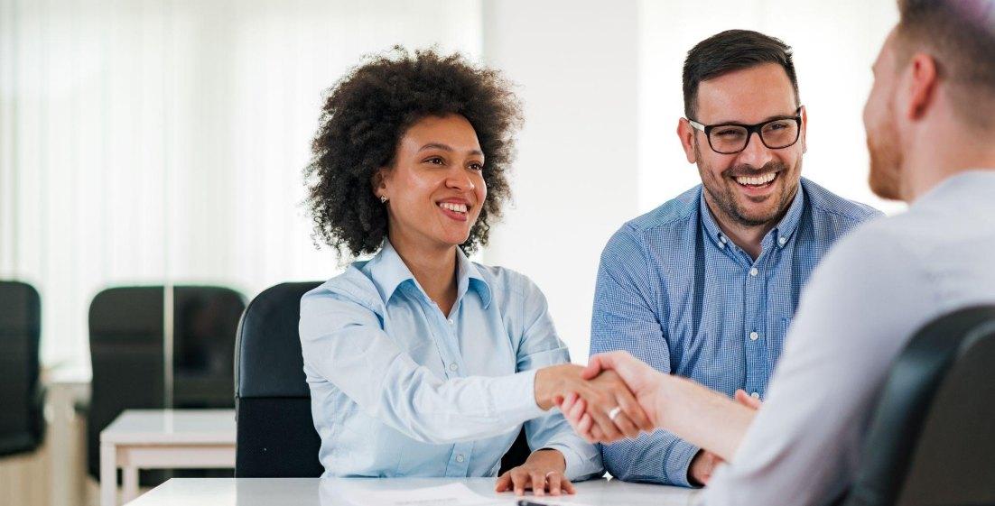 three people shaking hands after interview